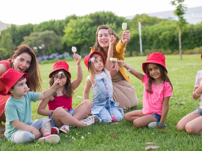 A joyful family enjoying ice cream on a sunny day in a Portuguese park.